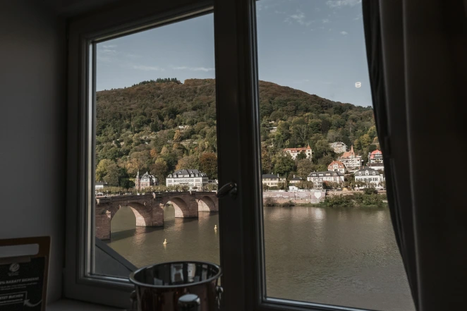 Wohnungen in Heidelberg mieten. Ausblick aus dem Fenster der BS Suites auf den Neckar und der Alten Brücke.